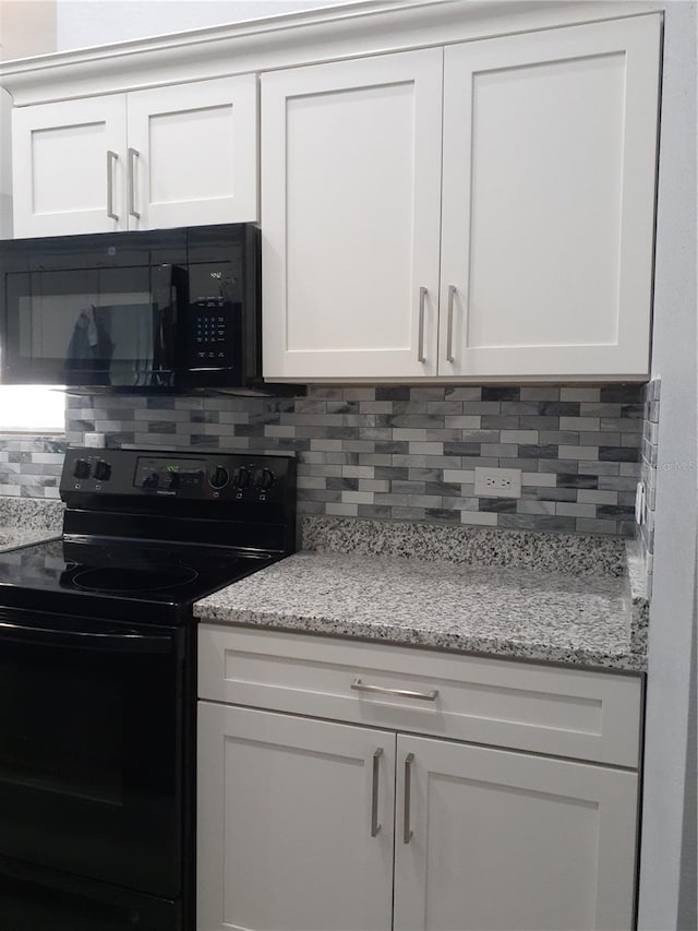 26 Clintwood Ave, Englewood, FL 34223 - kitchen featuring black appliances, tasteful backsplash, white cabinets, and light stone counters