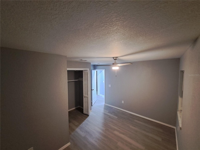 26 Clintwood Ave, Englewood, FL 34223 - unfurnished bedroom featuring dark wood-style flooring, a closet, a textured ceiling, and a ceiling fan