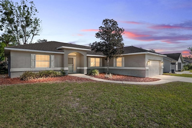 4575 NW 30th Pl, Ocala, FL 34482 - view of front of home with concrete driveway, stucco siding, a shingled roof, a garage, and a yard