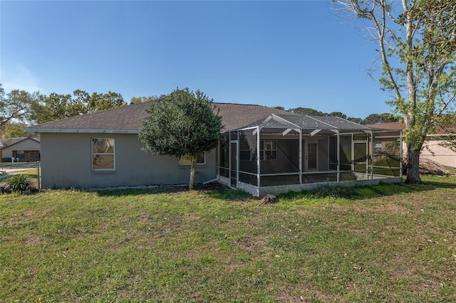 4575 NW 30th Pl, Ocala, FL 34482 - back of house featuring glass enclosure, a lawn, a shingled roof, and stucco siding