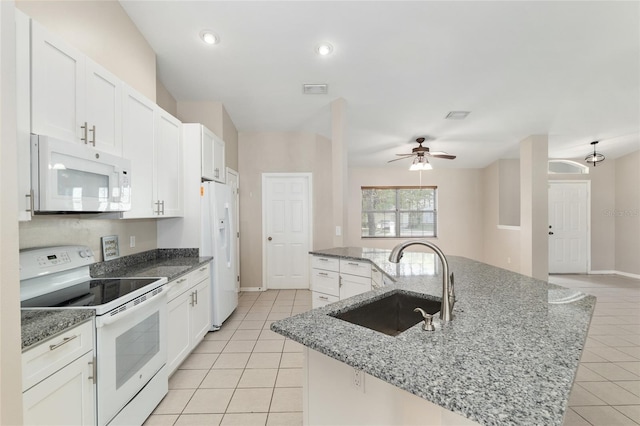 4575 NW 30th Pl, Ocala, FL 34482 - kitchen with a sink, a center island with sink, light tile patterned floors, white appliances, and white cabinets