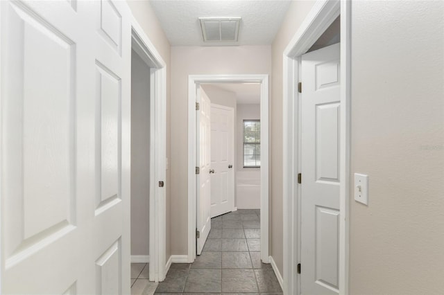 4575 NW 30th Pl, Ocala, FL 34482 - corridor featuring baseboards, visible vents, tile patterned flooring, and a textured ceiling