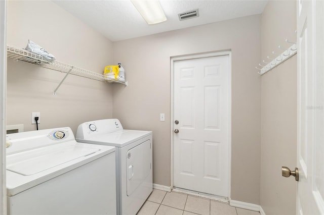 4575 NW 30th Pl, Ocala, FL 34482 - clothes washing area featuring washer and clothes dryer, laundry area, light tile patterned floors, baseboards, and visible vents
