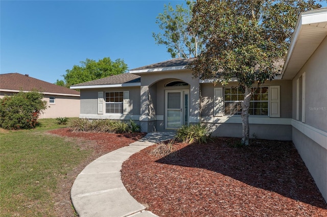 4575 NW 30th Pl, Ocala, FL 34482 - view of front of house with a shingled roof, a front yard, and stucco siding
