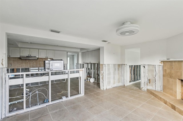 104 Carlyle Cir, Palm Harbor, FL 34683 - kitchen with light tile patterned floors, backsplash, and under cabinet range hood
