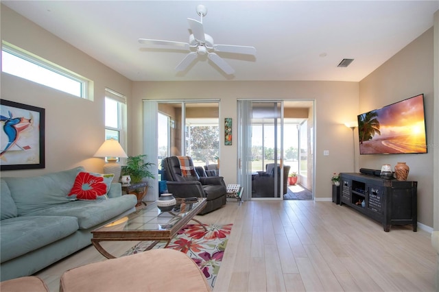 living area with ceiling fan, baseboards, light wood finished floors, and visible vents