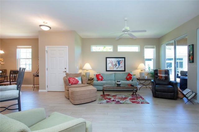 living room featuring baseboards, ceiling fan, and wood finished floors