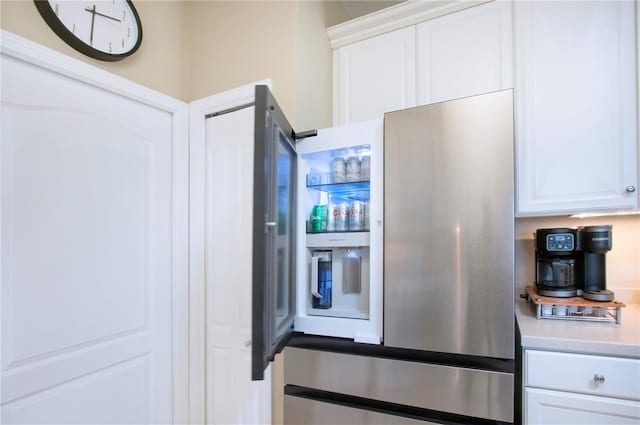 kitchen featuring white cabinetry, light countertops, and refrigerator with ice dispenser