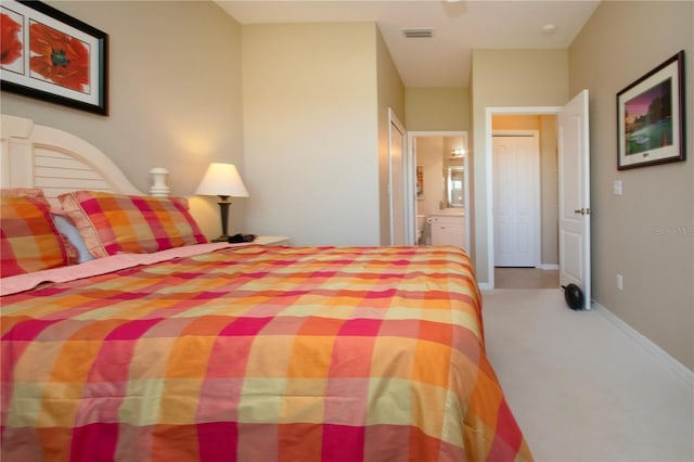bedroom with baseboards, ensuite bath, and visible vents