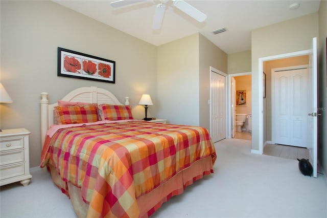 bedroom with carpet floors, ensuite bath, ceiling fan, and visible vents