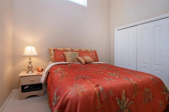 carpeted bedroom with baseboards and a closet