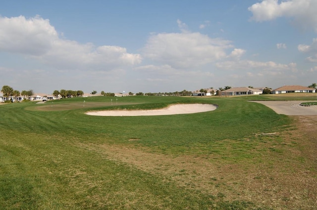 view of home's community featuring a lawn and view of golf course