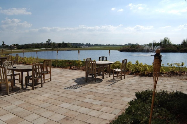 view of patio with a water view and outdoor dining area