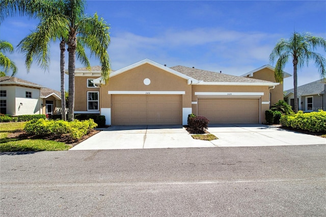view of front of house with stucco siding, an attached garage, and concrete driveway