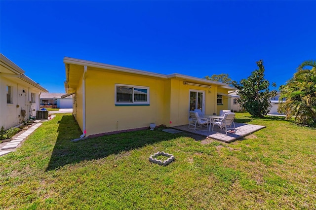 5427 Springwood Blvd Unit 5427, Pinellas Park, FL 33782 - back of property featuring a lawn, cooling unit, a patio area, and stucco siding