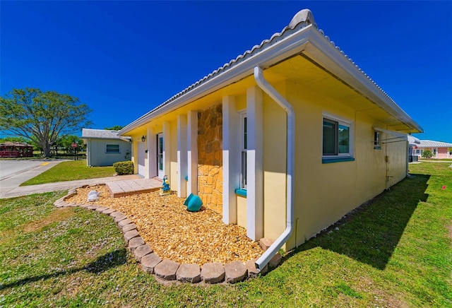 5427 Springwood Blvd Unit 5427, Pinellas Park, FL 33782 - view of side of home featuring a lawn, stucco siding, and stone siding
