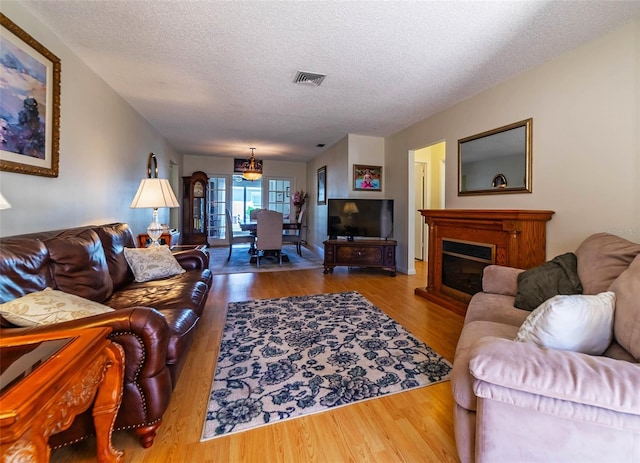 5427 Springwood Blvd Unit 5427, Pinellas Park, FL 33782 - living room featuring a glass covered fireplace, wood finished floors, a textured ceiling, and visible vents