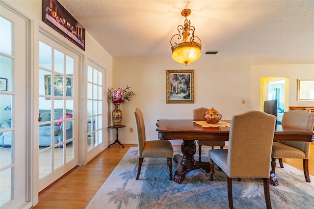 5427 Springwood Blvd Unit 5427, Pinellas Park, FL 33782 - dining space featuring visible vents, a textured ceiling, light wood-style flooring, and baseboards