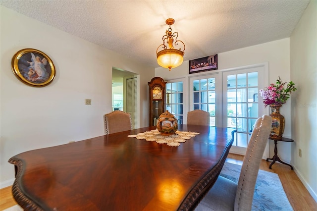 5427 Springwood Blvd Unit 5427, Pinellas Park, FL 33782 - dining room with baseboards, a textured ceiling, and light wood-style flooring