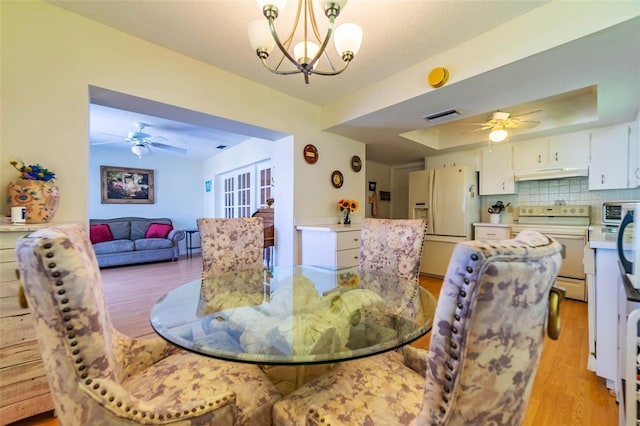 5427 Springwood Blvd Unit 5427, Pinellas Park, FL 33782 - dining room featuring a raised ceiling, ceiling fan with notable chandelier, light wood-style flooring, and visible vents