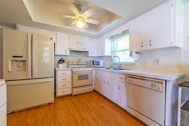 5427 Springwood Blvd Unit 5427, Pinellas Park, FL 33782 - kitchen featuring white appliances, light countertops, under cabinet range hood, a tray ceiling, and a sink