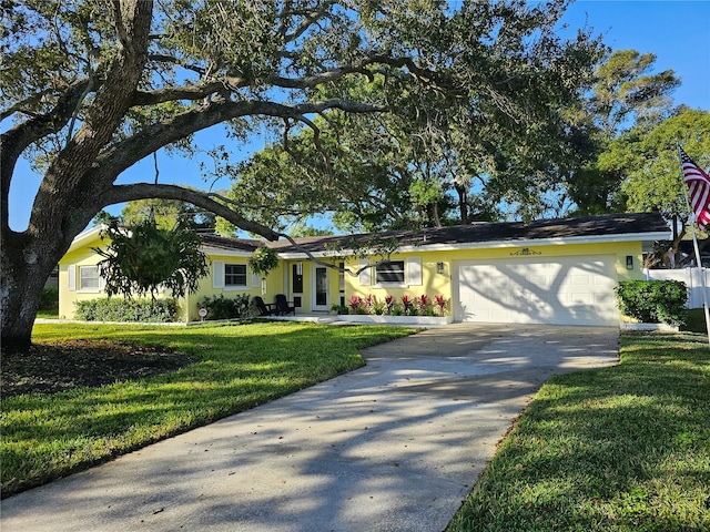 ranch-style home with concrete driveway, a garage, a front lawn, and stucco siding