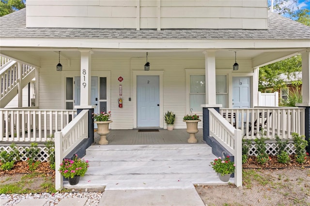 819 11th St N, Saint Petersburg, FL 33705 - view of exterior entry featuring covered porch and a shingled roof