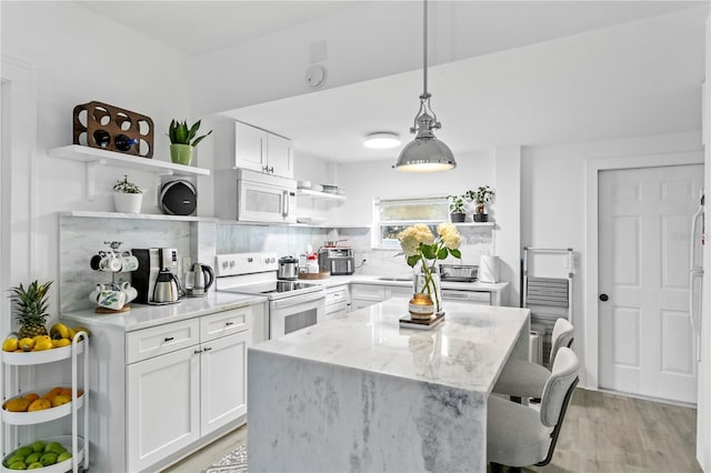 819 11th St N, Saint Petersburg, FL 33705 - kitchen with white appliances, open shelves, white cabinets, a kitchen bar, and backsplash