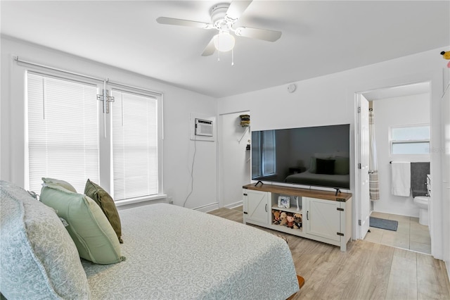 819 11th St N, Saint Petersburg, FL 33705 - bedroom with an AC wall unit, ensuite bath, a ceiling fan, and light wood finished floors