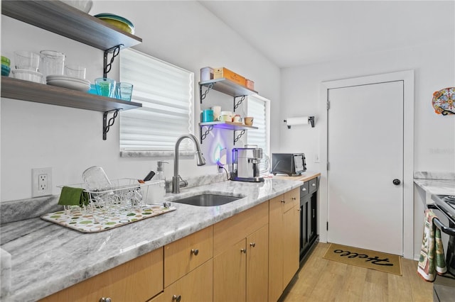 819 11th St N, Saint Petersburg, FL 33705 - kitchen featuring light wood-type flooring, light brown cabinets, open shelves, a sink, and light stone countertops