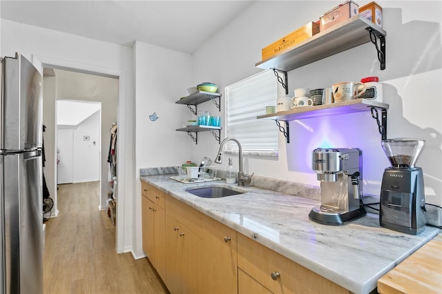 819 11th St N, Saint Petersburg, FL 33705 - kitchen with light brown cabinets, open shelves, light wood-type flooring, freestanding refrigerator, and a sink