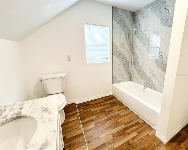 819 11th St N, Saint Petersburg, FL 33705 - full bath featuring toilet, wood finished floors, baseboards, vanity, and vaulted ceiling