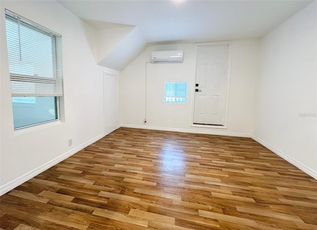 819 11th St N, Saint Petersburg, FL 33705 - additional living space featuring a wall unit AC, wood finished floors, and baseboards