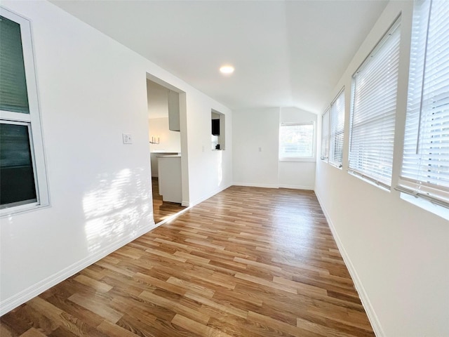 819 11th St N, Saint Petersburg, FL 33705 - spare room featuring light wood-type flooring, baseboards, and vaulted ceiling