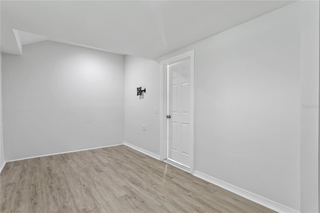 819 11th St N, Saint Petersburg, FL 33705 - empty room with lofted ceiling, wood finished floors, and baseboards