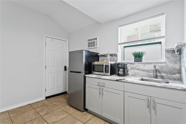 819 11th St N, Saint Petersburg, FL 33705 - kitchen featuring decorative backsplash, light stone countertops, appliances with stainless steel finishes, and a sink