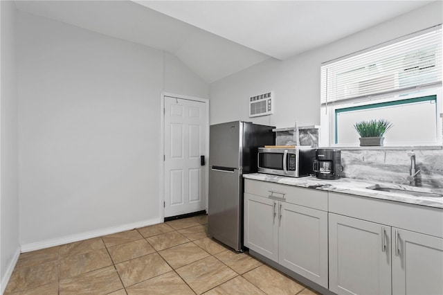 819 11th St N, Saint Petersburg, FL 33705 - kitchen featuring a wall mounted AC, a sink, backsplash, appliances with stainless steel finishes, and vaulted ceiling