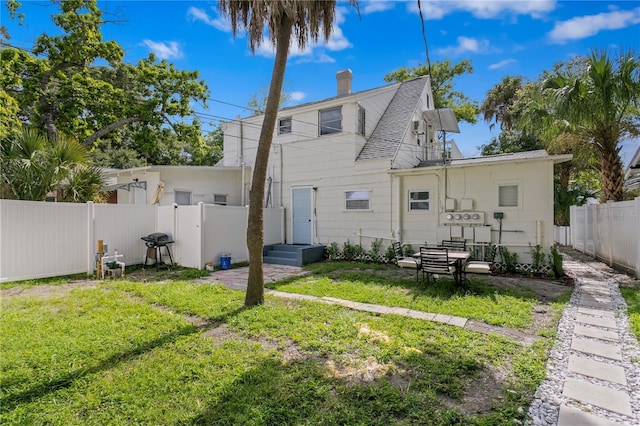 819 11th St N, Saint Petersburg, FL 33705 - rear view of house with a yard, a chimney, and a fenced backyard