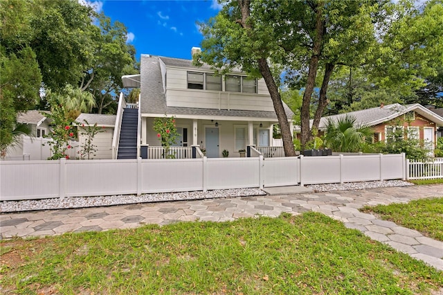 819 11th St N, Saint Petersburg, FL 33705 - view of front of house featuring a fenced front yard, covered porch, roof with shingles, and a gate