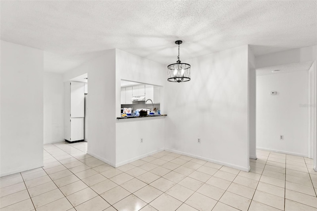 2650 Countryside Blvd Unit B102, Clearwater, FL 33761 - interior space featuring light tile patterned floors, baseboards, an inviting chandelier, and a textured ceiling