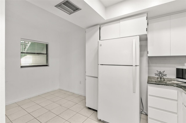 2650 Countryside Blvd Unit B102, Clearwater, FL 33761 - kitchen with light tile patterned floors, freestanding refrigerator, white cabinetry, visible vents, and stainless steel microwave