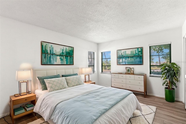 2650 Countryside Blvd Unit B102, Clearwater, FL 33761 - bedroom with a textured ceiling, wood finished floors, and baseboards