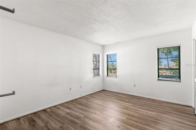 2650 Countryside Blvd Unit B102, Clearwater, FL 33761 - spare room with light wood-style floors, baseboards, and a textured ceiling