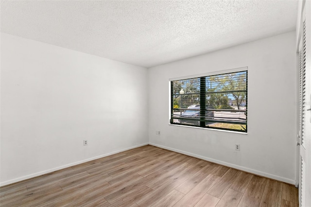 2650 Countryside Blvd Unit B102, Clearwater, FL 33761 - spare room with light wood-style flooring, a textured ceiling, and baseboards