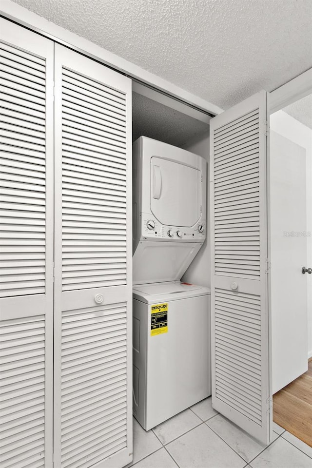 2650 Countryside Blvd Unit B102, Clearwater, FL 33761 - laundry area with laundry area, a textured ceiling, light tile patterned floors, and stacked washer and dryer