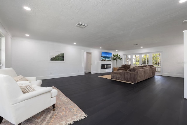 living room with recessed lighting, baseboards, visible vents, and dark wood finished floors