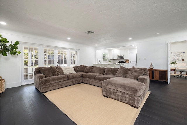 living room featuring french doors, recessed lighting, dark wood-style floors, and visible vents