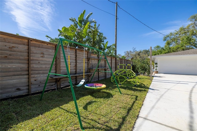 exterior space with a garage, a fenced backyard, and a playground