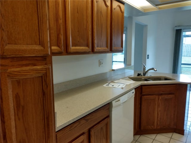 kitchen with dishwasher, light countertops, a peninsula, and a sink