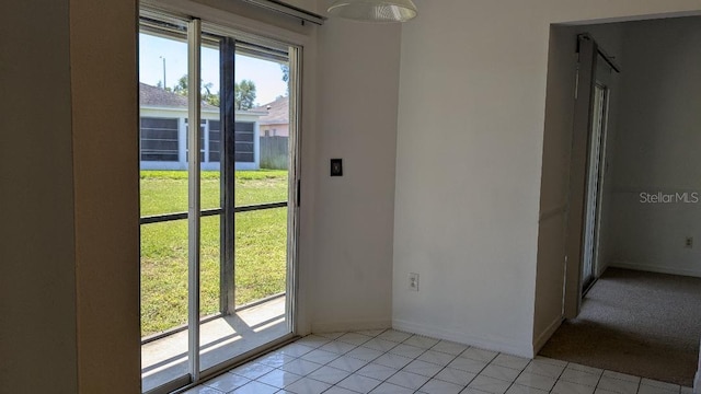 doorway featuring light tile patterned floors and baseboards